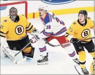  ?? Michael Dwyer / Associated Press ?? The Rangers’ Chris Kreider (20) plays against the Bruins’ Charlie McAvoy (73) and Jaroslav Halak (41) on Saturday.