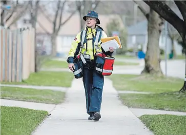  ?? MATHEW MCCARTHY WATERLOO REGION RECORD ?? Canada Post carrier Alison King enjoys being on her route. She still greets those who want say hi, but keeps her distance.