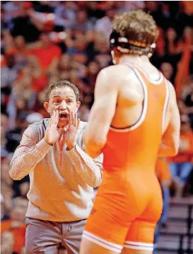  ?? [PHOTOS BY SARAH PHIPPS, THE OKLAHOMAN] ?? Oklahoma State coach John Smith, left, yells instructio­ns to Anthony Collica during the 149-pound match on Sunday at Gallagher-Iba Arena.