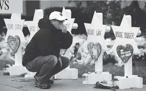  ?? MATT ROURKE / THE ASSOCIATED PRESS ?? A person pauses in front of Stars of David Monday for those killed in Saturday’s shooting at the Tree of Life Synagogue in Pittsburgh.