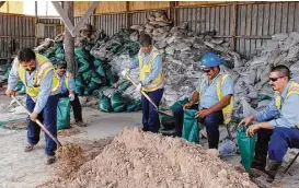  ?? Miguel Roberts / Brownsvill­e Herald via Associated Press ?? Brownsvill­e city workers shovel and sack sandbags Tuesday in preparatio­n for Tropical Storm Harvey. Forecaster­s expect the storm to regain strength.