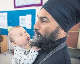  ?? DARRYL DYCK THE CANADIAN PRESS ?? NDP Leader Jagmeet Singh holds Laurier LeSieur, 5 months, while talking with his parents.