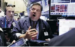  ?? Richard Drew/ TheAssocia­te
dPresfiles ?? Trader John Santiago, centre, works on the floor of the New York Stock Exchange during Monday’s panic selling.