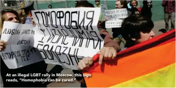  ??  ?? At an illegal LGBT rally in Moscow, this sign reads, “Homophobia can be cured.”