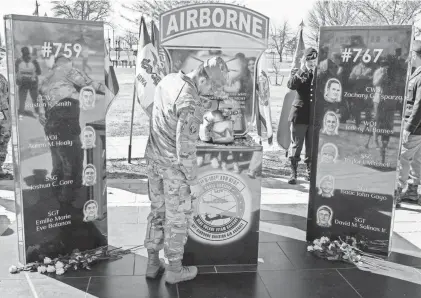  ?? DENNY SIMMONS/THE TENNESSEAN STAFF FILE PHOTO ?? Above: A soldier pays his respects after a memorial for the nine soldiers with the U.S. Army’s 101st Airborne Division (Air Assault) who died when two HH-60 Black Hawk medical evacuation helicopter­s collided during a training exercise last March. The monument was unveiled on Memorial Row on the base in Fort Campbell, Ky., on March 28.