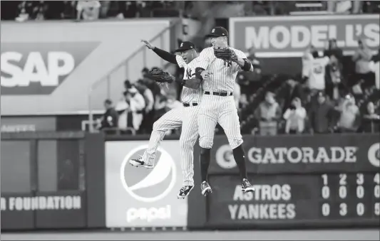  ??  ?? The New York Yankees’ Aaron Judge (right) and Aaron Hicks celebrate after defeating the Houston Astros in Game 3 of the American League Championsh­ip Series at Yankee Stadium on Monday, in New York City.