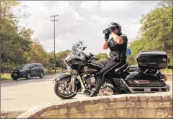  ?? RACHEL RICE / LAKE TRAVIS VIEW ?? Lakeway police officer Trevor Mathis keeps an eye on traffic from his motorcycle Aug. 21 along Lohmans Crossing Road.