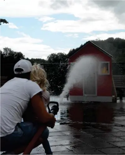  ?? FOTO: BERTINE MIDTTUN ?? Brannvesen­et Sør var tilstede på Barnas Dag. Her slukker Sofia og Vidar Olsen brannen.