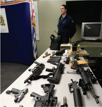 ?? CITIZEN FILE PHOTO ?? Police display a cache of guns seized by the RCMP in 2013.