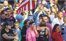  ?? AFP ?? People watch the procession carrying the body of a man killed in the mass shooting at the Borderline Bar and Grill, in Thousand Oaks, California.