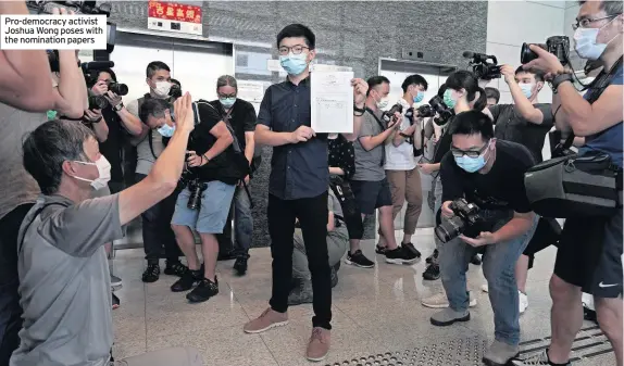  ??  ?? Pro-democracy activist Joshua Wong poses with the nomination papers