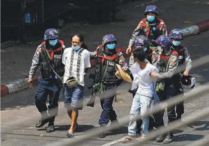  ?? SAI AUNG MAIN AFP VIA GETTY IMAGES ?? Police arrest people in Yangon, Myanmar, on Saturday as protesters were taking part in a demonstrat­ion against the military coup. Dozens were arrested at protests across the country as police orders intended to curb the demonstrat­ions.