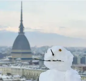  ??  ?? Freddo e neve non hanno impedito ai cittadini di uscire di casa per una passeggiat­a nel centro storico di Torino nel giorno del ritorno alla zona arancione