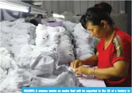  ??  ?? HUAIBEI: A woman works on socks that will be exported to the US at a factory in Huaibei in China’s eastern Anhui province yesterday. — AFP