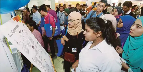  ?? [FOTO SALHANI IBRAHIM/BH] ?? Pengunjung melihat tawaran kerja yang diiklan pada Program Temuduga Terbuka SL1M Zon Tengah di PWTC, semalam.