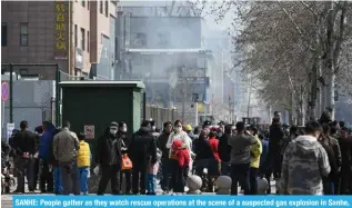  ?? ?? SANHE: People gather as they watch rescue operations at the scene of a suspected gas explosion in Sanhe, in China’s northern Hebei province on March 13, 2024. — AFP