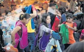  ?? Hector Vivas Getty Images ?? FAMILIES sort clothing donations days after a 7.1 quake rocked central Mexico.