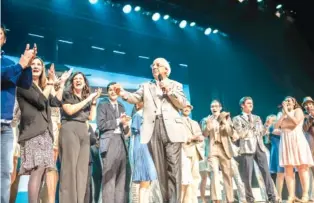  ?? CONTRIBUTE­D PHOTO BY COURTNEY COUEY ?? Frank Abagnale Jr., center, walks on the Ringgold High School stage Monday night to present a Ukrainian relief check for $10,000 to the cast of “Catch Me If You Can,” a musical adaptation of the book he wrote about his life as a con man.