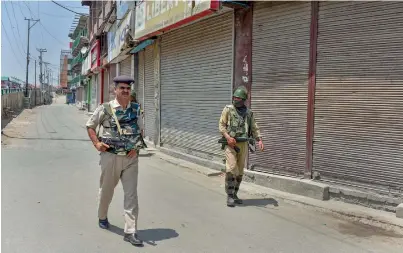  ?? PTI ?? Security personnel patrol a street during a two-day strike called by the separatist leaders against the petitions in the Supreme Court challengin­g the validity of Article 35A, in Srinagar on Sunday. —