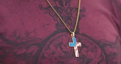  ?? ALLISON DINNER/AP ?? A congregant wears a cross decorated with a U.S. flag pattern Oct. 16 at Saddleback Church in Lake Forest, California.