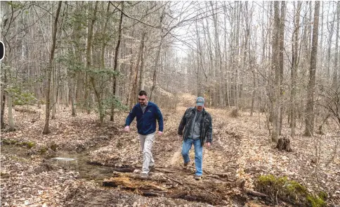  ??  ?? James Morelli and Edwin Moses of Origis Energy walk through Charles County, Maryland, land on Feb 14 and (below�� Edwin Moses of Origis Energy goes over a map of wooded Charles County, Maryland, land on Feb 14. — WP–Bloomberg photos by Mary F. Calvert.