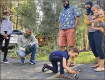  ?? PETER ORSI / ASSOCIATED PRESS ?? Vivian Filipic, 4, plays with a toy motorcycle in a driveway in Truckee, California, on June 19, the day before her fifth birthday, in front of Scarlett Fierro (from left), Craig Fierro, Vivian’s parents Filip Filipic and Kirsten Mickelson, and her brother Luca Filipic, 9 months.