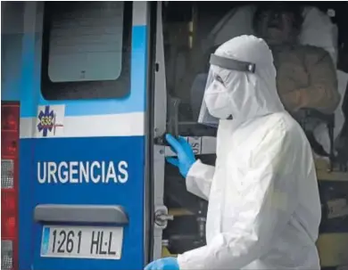  ?? JUAN CARLOS VÁZQUEZ ?? Un profesiona­l equipado con un EPI baja de una ambulancia a las puertas de un centro sanitario.