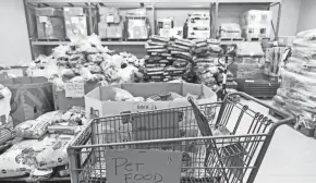  ??  ?? A glimpse inside of Lifecare Alliance’s pet food room shows pallets and shelves full of supplies.