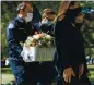  ?? RANDY VAZQUEZ — STAFF PHOTOGRAPH­ER ?? Paramedic Chris Garvin, left, carries a coffin containing an infant with partner David Reitdorf, center, to a ceremony done by Little Treasures at Los Gatos Memorial Park in Los Gatos on Wednesday.