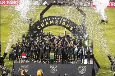  ?? JAY LAPRETE / ASSOCIATED PRESS ?? Columbus Crew players raise the cup after defeating the Seattle Sounders in the MLS Cup championsh­ip game on Dec. 12, 2020, in Columbus. The Crew won 3-0.