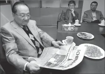  ?? EDMOND TANG / CHINA DAILY ?? Louis Cha reads China Daily while visiting the newspaper’s Hong Kong office in 2005.