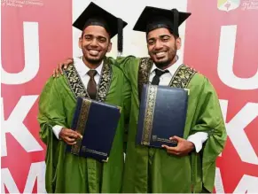  ??  ?? Two of a kind: Hari (left) and Giri are all smiles after receiving their scrolls at UKM’s convocatio­n ceremony.