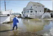  ?? STEVEN SENNE — THE ASSOCIATED PRESS ?? A resident of Duxbury, Mass., views flooding near her home, Sunday in Duxbury. The Northeast is bracing for its third nor’easter in fewer than two weeks. The National Weather Service reports that a southern storm is expected to make its way up the...