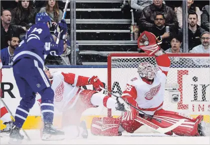  ?? FRANK GUNN THE CANADIAN PRESS ?? Detroit Red Wings goaltender Jimmy Howard makes a spectacula­r glove save off the stick of Maple Leafs centre Auston Matthews, left, in the first- period Saturday night in Toronto.