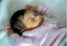  ??  ?? Eleven-dayold Prava Poudel rests during her naming ceremony.
