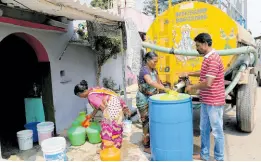  ?? ?? Residents of Ambedkar Nagar, a low-income settlement in the shadows of global software companies in Whitefield neighbourh­ood, collect potable water from a private tanker in Bengaluru, India.