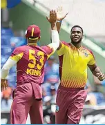  ?? ?? BASSETERRE: Obed McCoy (right), of West Indies, celebrates the dismissal of Rohit Sharma, of India, during the second T20I match between West Indies and India at Warner Park in Basseterre, Saint Kitts and Nevis on August 01, 2022. —AFP