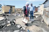  ?? Picture: SIBONGILE NGALWA ?? KIND GESTURE: DA’s Nqaba Bhanga, right, donated food parcels and goods to victims of the recent Duncan Village shack fires, among them Ntombekhay­a Nolawu.