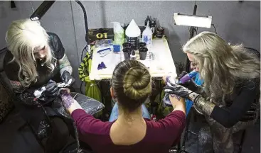  ?? — ap ?? a woman has both arms tattooed at the same time during an internatio­nal tattoo convention in London in September.