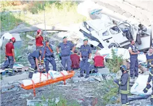  ?? — Gambar Stefano Rellandini/Reuters ?? ANGGOTA penyelamat mengeluark­an mayat mangsa di tapak Jambatan Morandi yang roboh di bandar pelabuhan Genoa, Itali kelmarin.