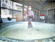  ?? - Photo by Chimon Upon ?? Cook, Yusuf Shah, stirs the thick porridge in a large pot.