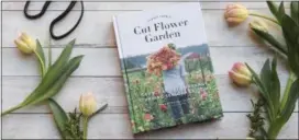  ?? IRENE KIM — CHRONICLE BOOKS VIA AP ?? This 2017 photo provided by Chronicle Books shows Erin Benzakein’s book, “Floret Farm’s Cut Flower Garden,” and is surrounded by tulips, one of the first bloomers each spring, in San Francisco