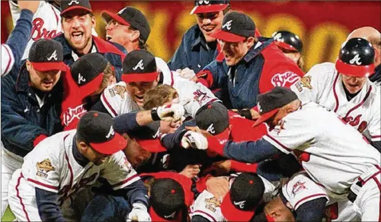  ?? AJC ?? As Skip Caray told the world what it meant to Atlanta, Braves players celebrate winning the 1995 World Series championsh­ip.