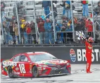  ?? THE ASSOCIATED PRESS ?? Kyle Busch celebrates with fans after winning the Food City 500 on Monday at Bristol Motor Speedway.