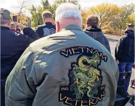  ?? [PHOTO BY WILLIAM CRUM, THE OKLAHOMAN] ?? Head bowed, Vietnam veteran Patrick Nelson stands for the playing of taps on Thursday at a ceremony marking the arrival in Oklahoma City of The Wall That Heals, a replica of the Vietnam Veterans Memorial in Washington, D.C. The Wall is open to the...