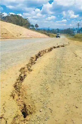  ?? RENAGI RAVU ?? A large crack forms on a highway near the town of Kainantu after a magnitude 7.6 earthquake struck Sunday in Papua New Guinea. At least three people were killed and others were hurt from falling debris in the gold-mining town of Wau, authoritie­s said. Renagi Ravu, a geologist, said the quake “was quite intense.” Papua New Guinea is located on the eastern half of the island of New Guinea, to the east of Indonesia and north of eastern Australia.