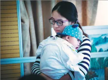  ?? XU KE / FOR CHINA DAILY ?? A mother and her baby from Tianjin attend a meeting held last year by the Shanghai Debra Butterfly Babies Care Center, which has more than 800 patients with Epidermoly­sis bullosa from all over the country.