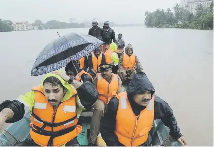  ?? Picture: AFP ?? AFLOAT. Indian fire and rescue personnel evacuate local residents in an boat following monsoon rains at Aluva, in the Indian state of Kerala, yesterday. The death toll in the Indian tourist spot increased to about 100 as torrential rain threatened new areas, officials said.