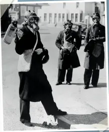  ??  ?? ABOVE AN Air Raid Warden sounds her gas rattle in Kingston upon Thames during a gas alarm. April 1941