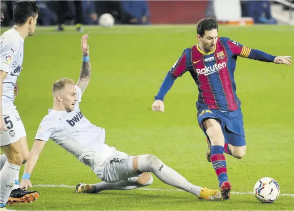  ?? (Photo: AFP) ?? Valencia’s Serbian midfielder Uros Racic (centre) vies with Barcelona’s Argentinia­n forward Lionel Messi during the Spanish league football match at Camp Nou stadium in Barcelona on Saturday.